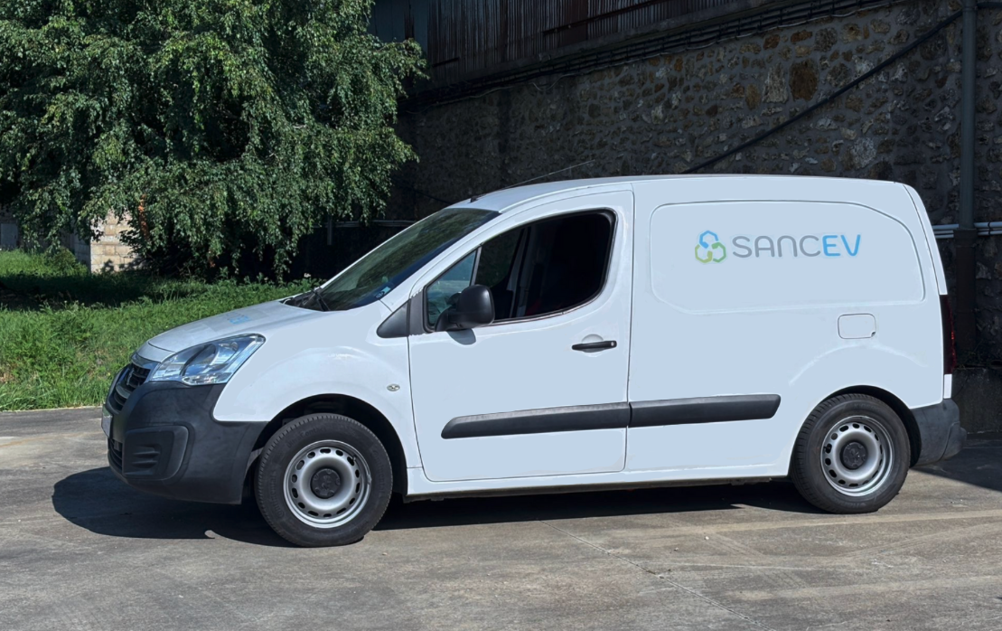 Utilitaire SANCEV électrifié devant un mur en pierre